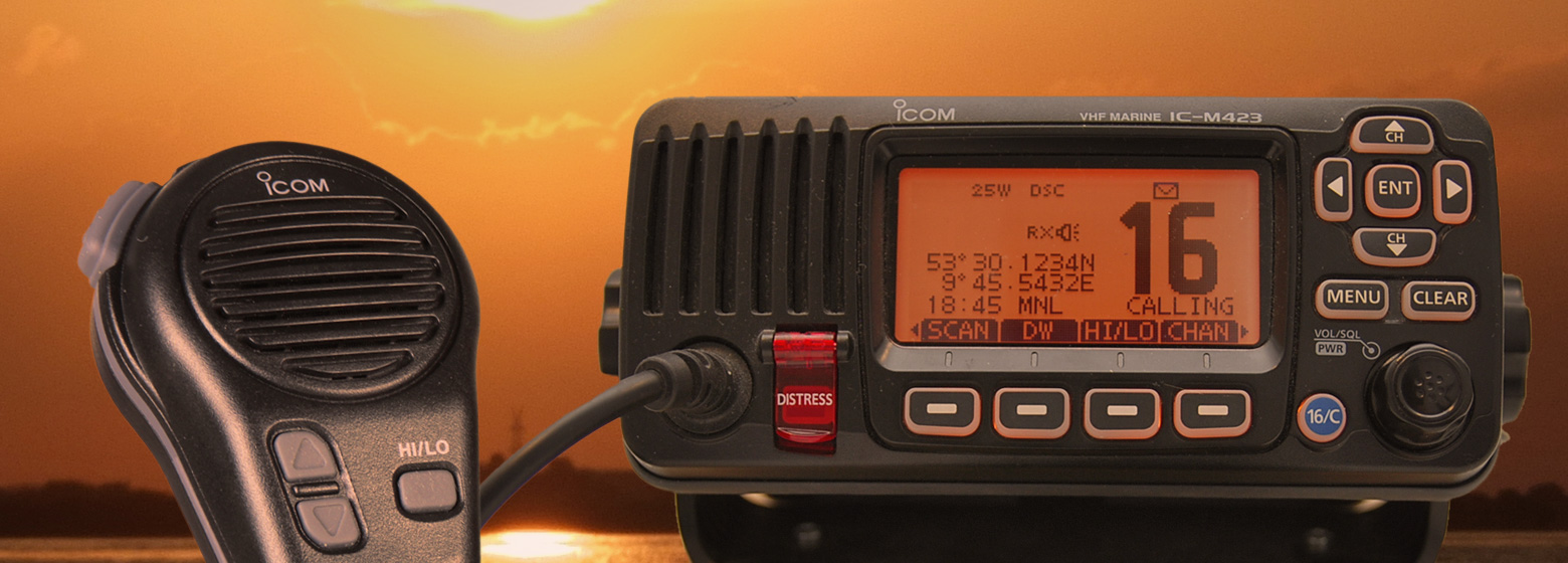 Ein modernes DSC-Funkgerät mit dem Handset im rechten Drittel des Bilder und die rechten zwei Drittel zeigt das Display auf dem der UKW-Kanal 16 eingestellt ist. Die DSC-Notruftaste ist zu erkennen und die weiteren Bedienknöpfe für das Funkgerät.